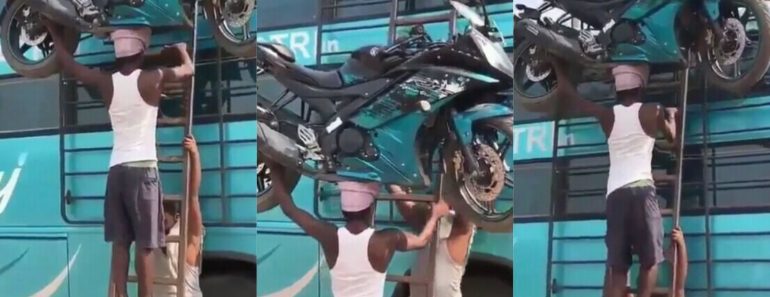 Ghanaian in India breaks the internet as he climbs a ladder with a huge motorbike on his head (Video)